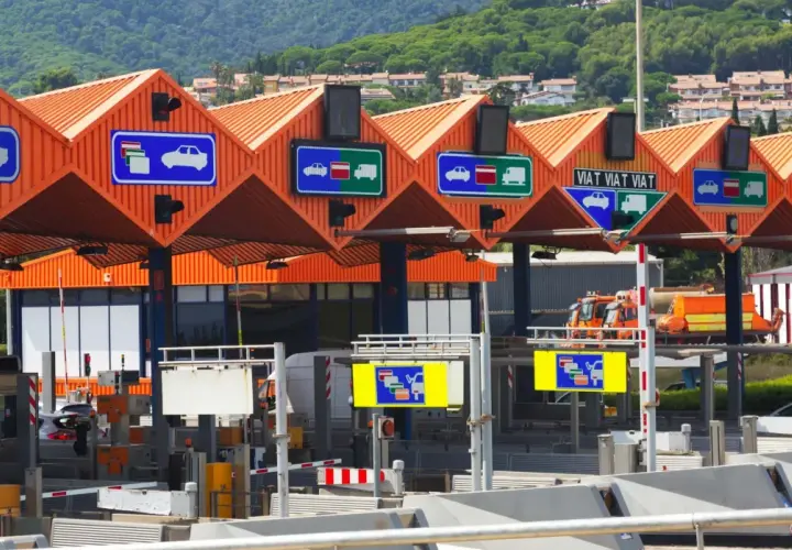 Carriles de peaje con señales que indican cómo pagar. Hay señales para coches y camiones, y una para pago manual.
