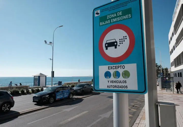 Señal de "Zona de Bajas Emisiones" (ZBE) con un coche y puntos de emisión. Indica excepciones para vehículos con distintivos C, ECO y 0.