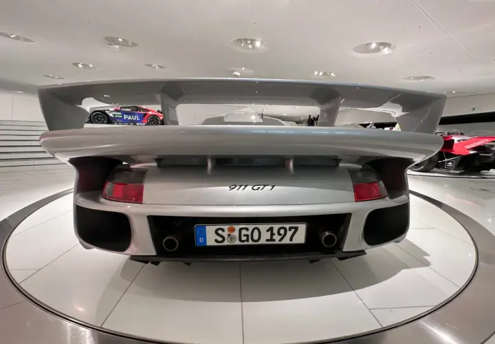 Srebrne Porsche 911 GT1 z masywnym spojlerem, gotowe do wyścigu.