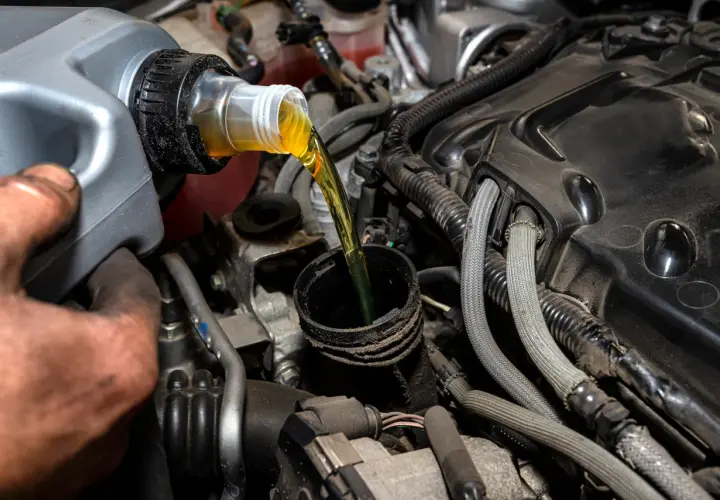 Vertiendo aceite de motor, una tarea común al considerar la diferencia entre aceite 5w40 y 10w40.