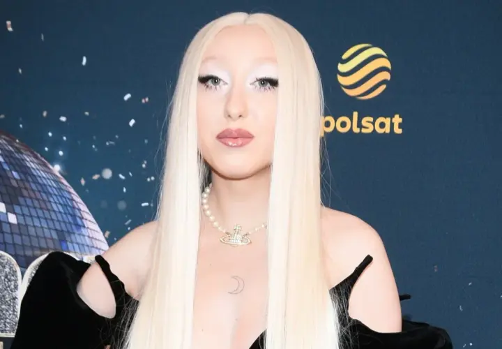 Luna w stylizacji na Eurowizję, z długimi blond włosami i perłowym naszyjnikiem.