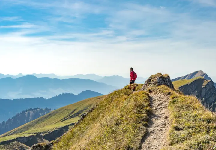 Wanderer auf einem Bergkamm in Deutschland, mit Blick auf eine weite Alpenlandschaft.