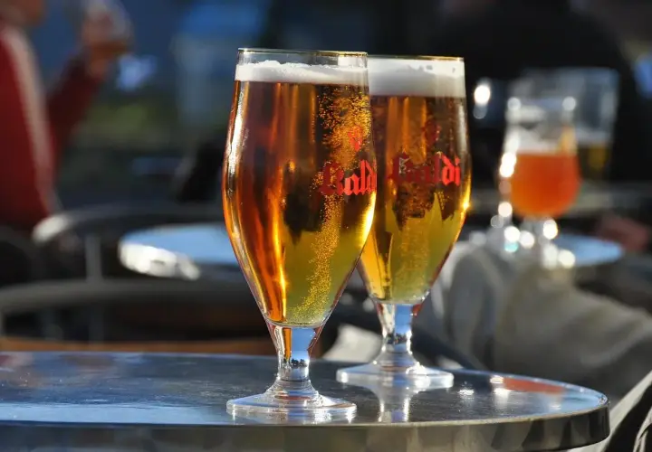 Dwa kieliszki złocistego piwa z pianką, idealne do degustacji aromatów i goryczki dzięki najlepszym technikom chmielenia na zimno (dry hopping).