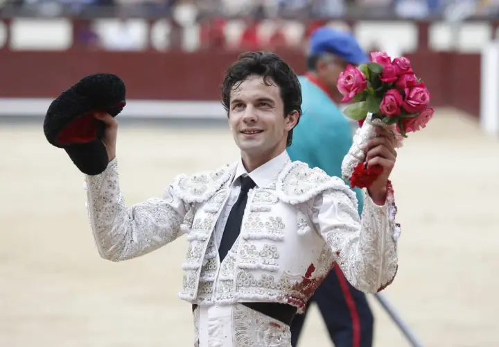 Juan del Álamo, torero, sonríe con un ramo de rosas en la mano y su montera en la otra, tras una faena.