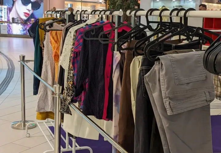 Wiesz, co zrobić ze starymi ubraniami? Wieszak pełen ubrań na sprzedaż lub wymianę w centrum handlowym.