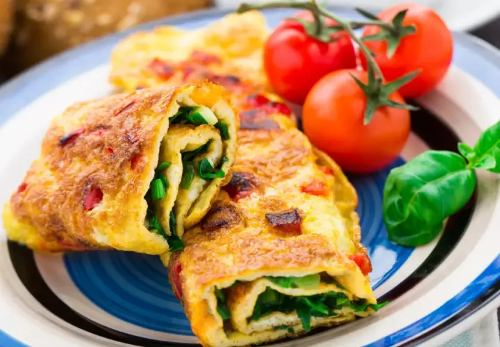 Roladki z omletu z zielonymi warzywami i pomidorkami koktajlowymi. Pyszne śniadanie bez chleba.