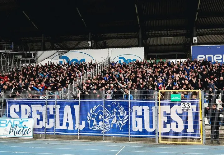 Trybuna kibiców Ruchu Chorzów z transparentem "SPECIAL GUEST". Fani pozdrawiają, a na płocie widać numer 33.