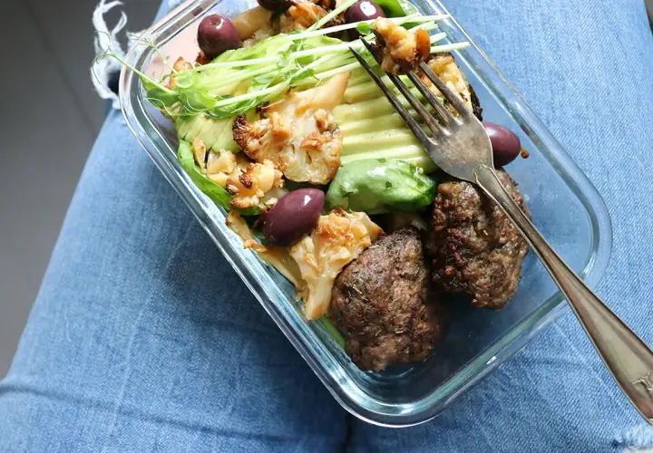 En snabb matlåda med köttbullar, blomkål, avokado och oliver. Perfekt för en hälsosam lunch på språng.