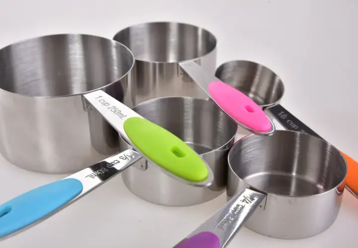 Zestaw metalowych miarek kuchennych z kolorowymi uchwytami.