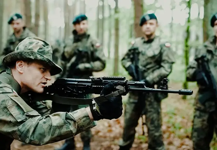 Żołnierze na szkoleniu podstawowym wojsko ćwiczą celowanie z karabinów w lesie.
