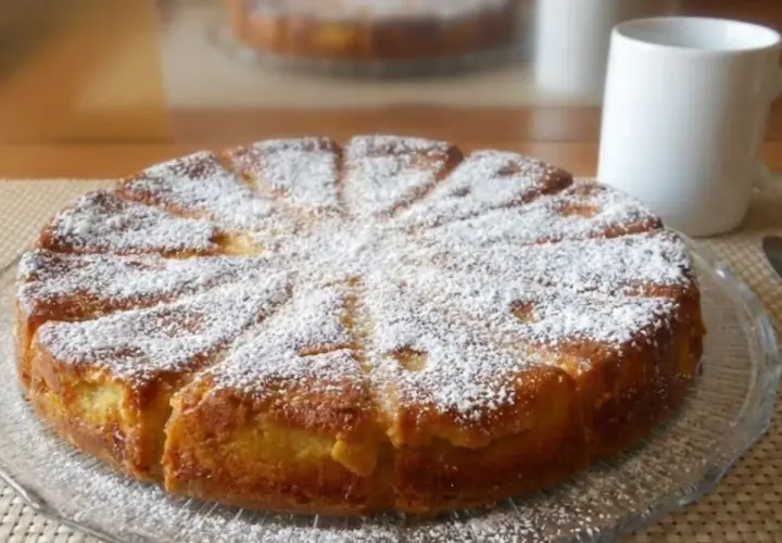 Gâteau mascarpone saupoudré de sucre glace, prêt à être dégusté avec une tasse de café.