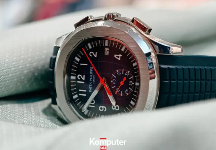 Elegancki zegarek Patek Philippe, model inspirowany stylem Marie Philippe, z czarną tarczą i gumowym paskiem, leży na zielonym materiale.
