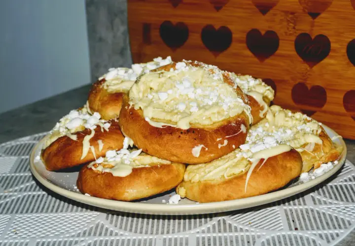Pyszne drożdżówki bez mleka z kremowym nadzieniem i posypką z cukru pudru. Idealne na deser lub słodką przekąskę.