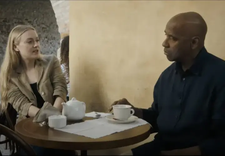 Denzel Washington i Dakota Fanning rozmawiają przy stoliku w kawiarni. To scena z filmu "Bez litości obsada".