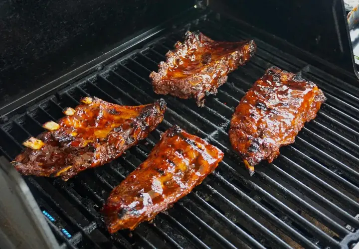 Soczyste żeberka w sosie barbecue grillują się na ruszcie. Idealne do marynowania w domowych sosach.