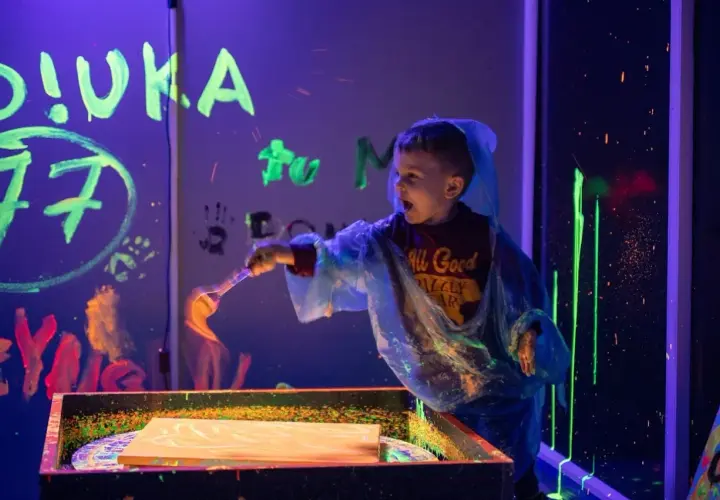 Chłopiec maluje farbami fluorescencyjnymi w ciemni. Niezapomniane urodziny dziecka w Szczecinie.