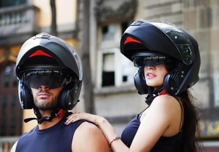 Pareja lista para rodar con sus cascos modulares, ofreciendo protección y estilo.