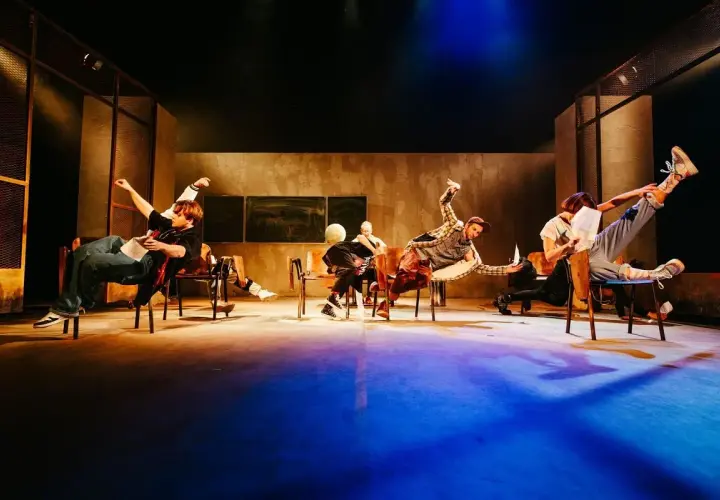 Aktorzy Teatru Lalek Pleciuga w dynamicznych pozach na scenie, unoszący się w powietrzu.