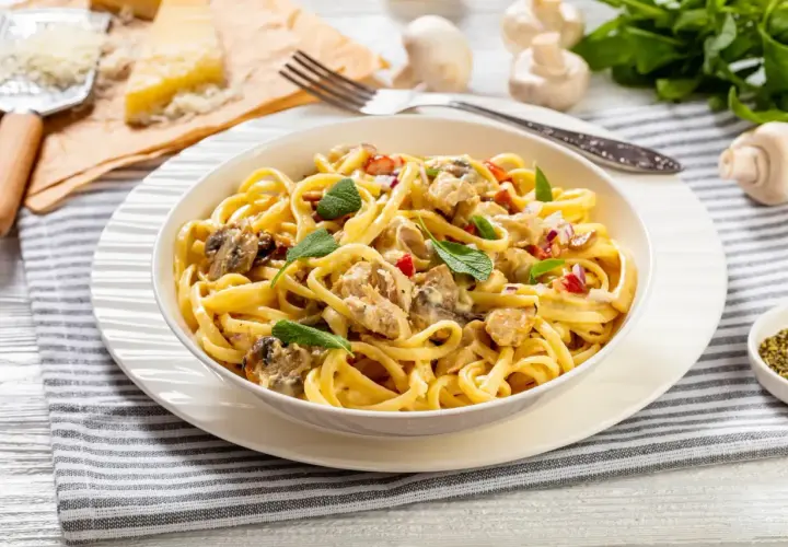 Un plat de pâtes crémeuses, un délice "one pot pasta" avec poulet, champignons et herbes fraîches.