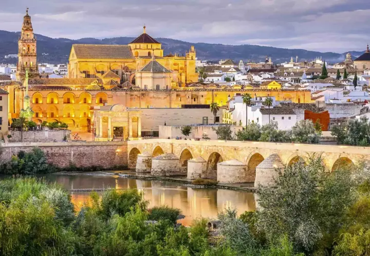 Puente Romano y Mezquita-Catedral de Córdoba, un ave que vuela sobre la historia, evocando un viaje desde Barcelona.