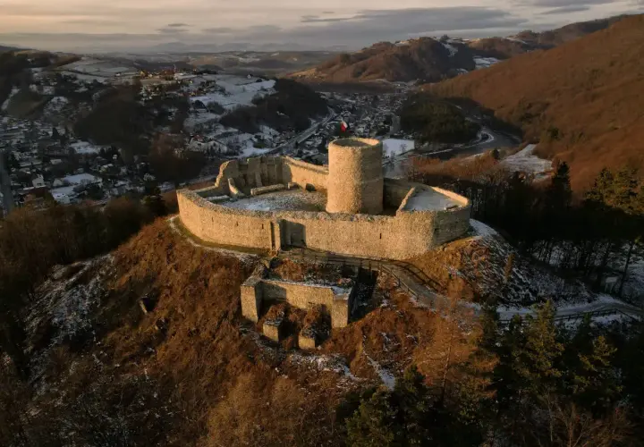 Ruiny zamku na wzgórzu, z widokiem na ośnieżoną dolinę i miasteczko. Wspaniałe rytro atrakcje dla miłośników historii.