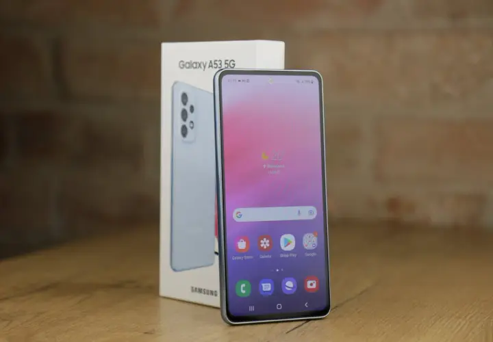 Jasnoniebieski Samsung A53 5G, model z 2022 roku, obok swojego pudełka. Ekran pokazuje pogodę i ikony aplikacji.