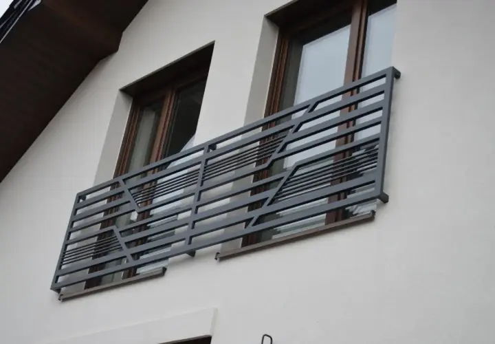 Nowoczesne balkony francuskie z metalową, geometryczną balustradą zdobią elewację domu.