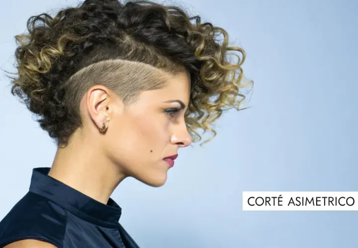 Mujer con pelo corto rizado juvenil, rapado a los lados y con volumen arriba. Un corte asimétrico que resalta su estilo audaz.
