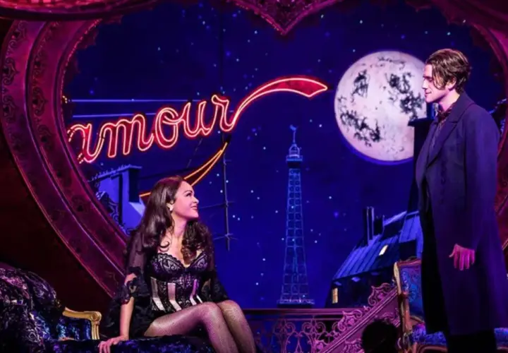 Para młodych kochanków na tle neonowego napisu "Amour" i księżyca, w scenerii przypominającej paryski nocny klub Moulin Rouge!