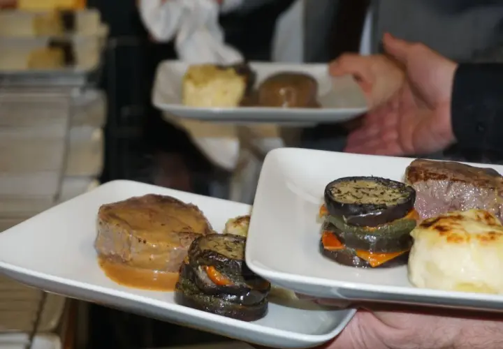 Un délicieux repas chaud de mariage avec des médaillons de bœuf, des légumes grillés et une purée gratinée.