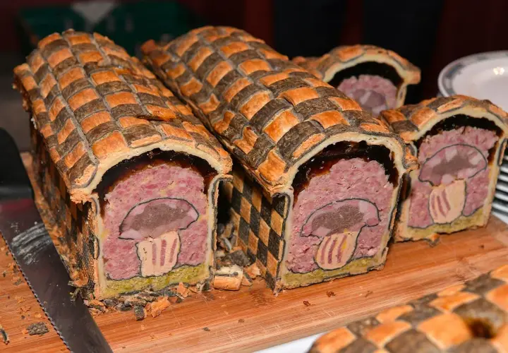 Pâté en croûte d'origine, décoré d'un champignon stylisé. Une œuvre culinaire qui raconte l'histoire de ce plat traditionnel.
