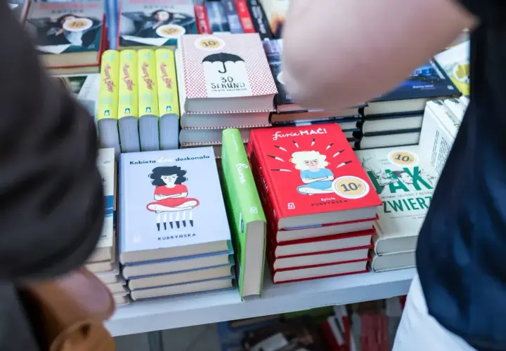 Na półce stoją książki, m.in. "Kobieta dość doskonała" i "Furia maći". Zastanawiasz się, ile zarabia autor na jednej sprzedanej książce procenty i tantiemy?