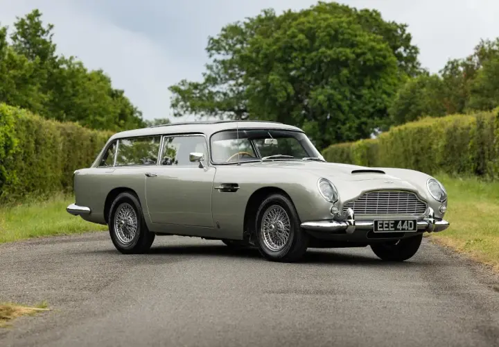 Srebrny Aston Martin DB5 Shooting Brake na tle zieleni. Klasyk z lat 60. w unikalnej wersji kombi.