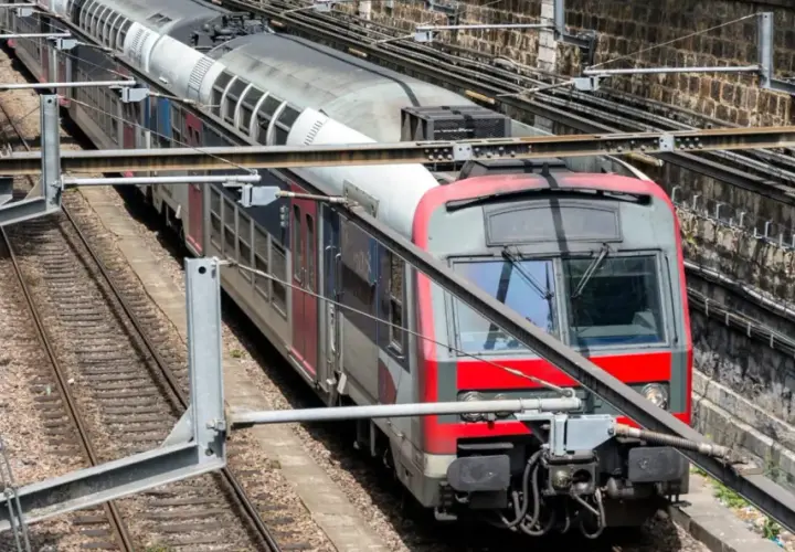 Pociąg RER A w Paryżu na torach, z widocznymi elementami infrastruktury kolejowej.