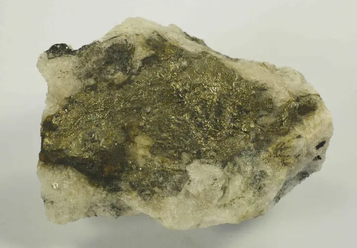 Gestein mit glänzenden, goldfarbenen Pyrit-Kristallen. Vorsicht, Pyrit ist giftig!