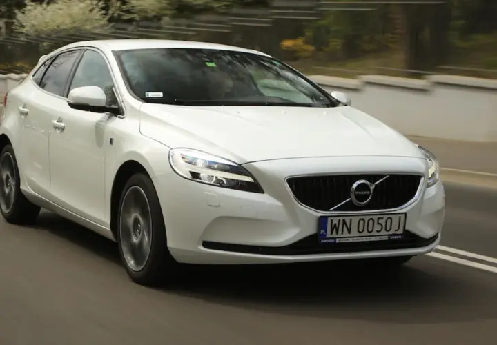 Białe Volvo V40 D2 w ruchu miejskim, z widocznym numerem rejestracyjnym WN 0050J.