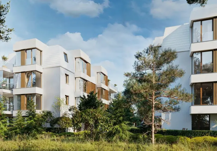 Nowoczesna sopocka architektura, białe budynki z drewnianymi elementami i dużymi oknami, otoczone zielenią.