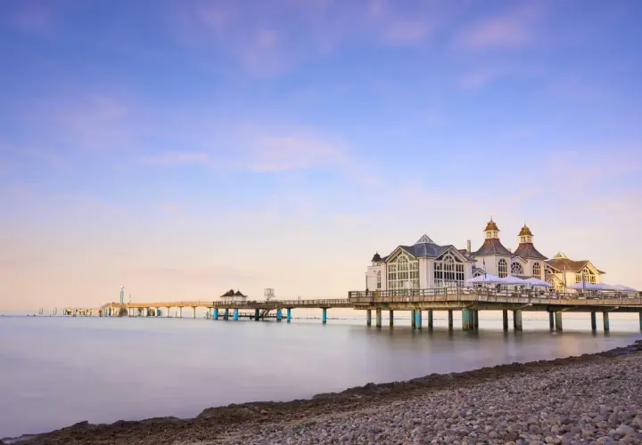 Die Seebrücke im Ostseebad Sellin erstreckt sich ins ruhige Meer. Ein malerischer Anblick bei Sonnenuntergang.