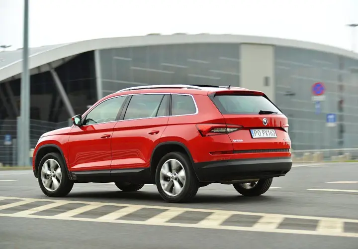 Czerwona Skoda Kodiaq w ruchu. Wiele pozytywnych skoda kodiaq opinie potwierdza jej wszechstronność.