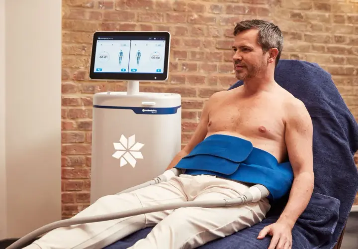 Man får behandling med CoolSculpting för att reducera fett på magen.