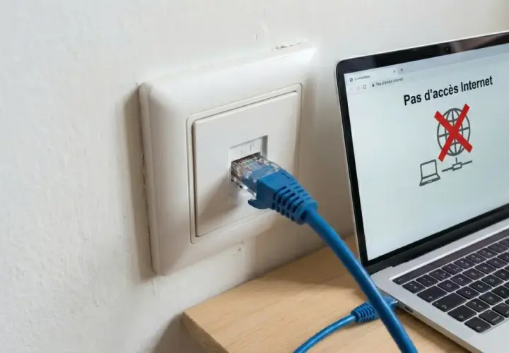 Câble RJ45 branché sur une prise murale, mais l'ordinateur affiche "Pas d'accès Internet". Problème de connexion réseau, peut-être un switch RJ45 sans alimentation.