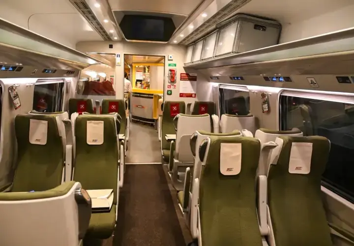 Wnętrze wagonu PKP Intercity. Zielone siedzenia bez gwarancji miejsca do siedzenia czekają na pasażerów.