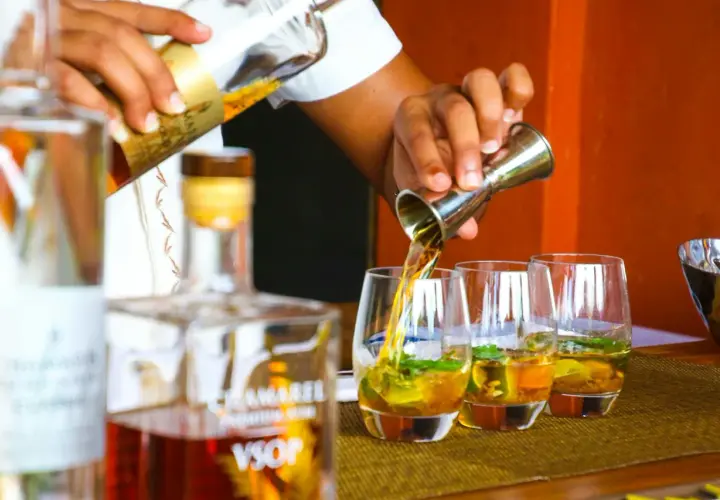 Barman nalewa likier do szklanek. W tle butelka z napisem VSOP. Zastanawiasz się, ile procent ma likier?