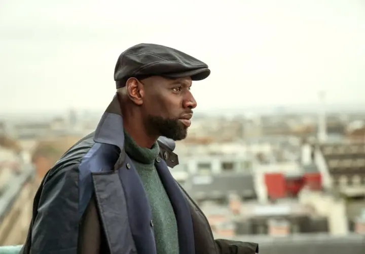 Omar Sy jako Assane Diop w czapce i płaszczu, spogląda w dal na tle Paryża. Czy to zapowiedź lupin sezon 4?