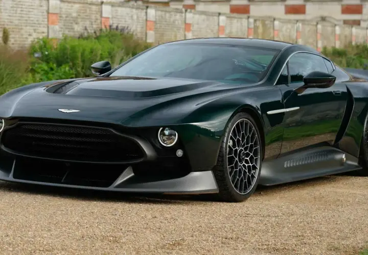 Der Aston Martin Victor, ein dunkelgrüner Supersportwagen, steht auf einem Kiesweg vor einer alten Mauer.