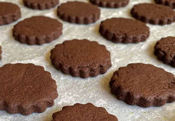 Deliziosi biscotti senza burro al cacao, con bordo ondulato, pronti per essere gustati.