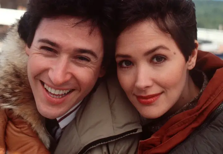 Uśmiechnięci John Cusack i Annette Bening, główni bohaterowie filmu "Przystanek Alaska", w zimowych kurtkach.
