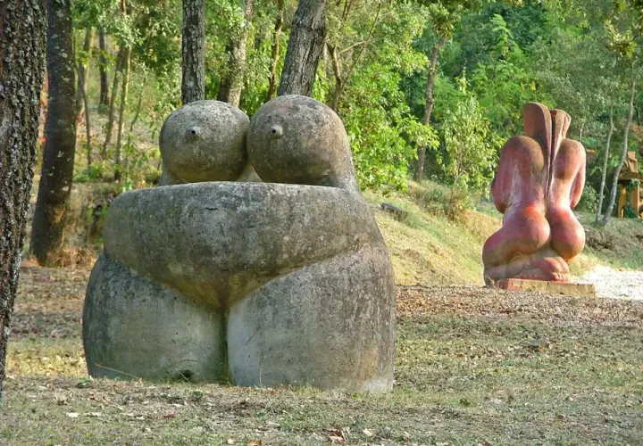 Esculturas de piedra en un museo al aire libre, evocando formas humanas en un entorno natural.