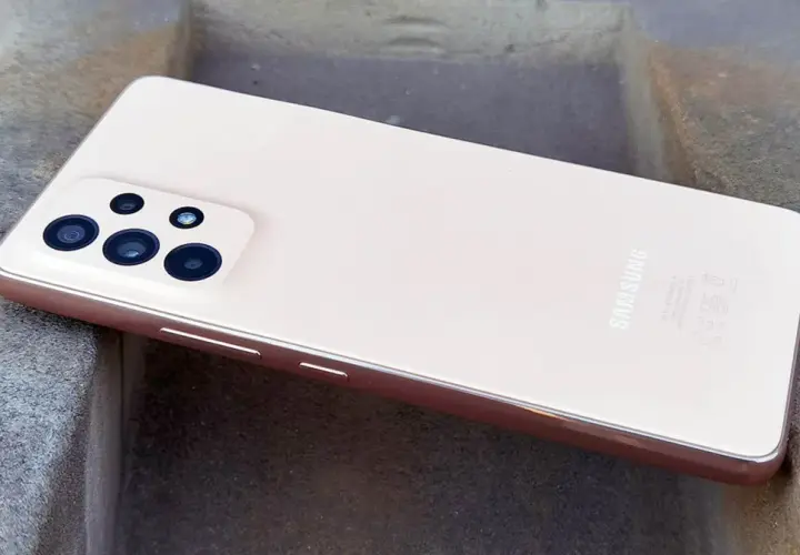 Różowy Samsung A53 z aparatem na kamiennym tle.