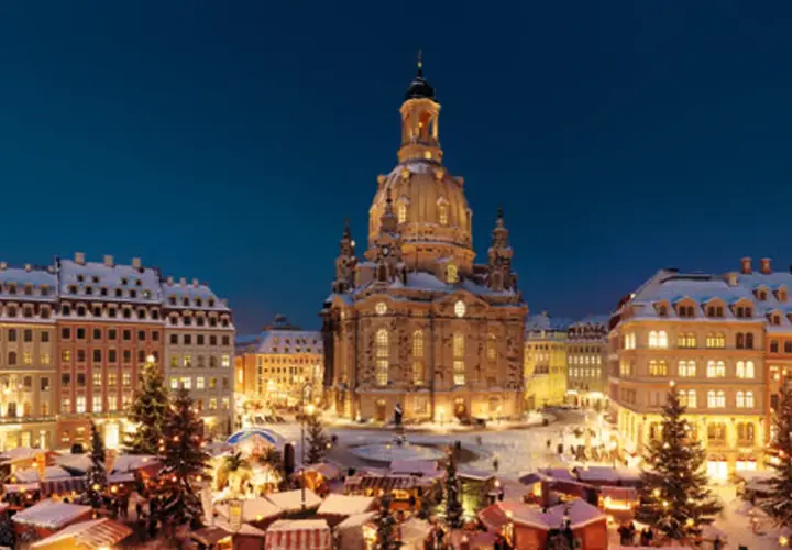 Śnieżny jarmark w Dreźnie. W tle Frauenkirche, po bokach oświetlone kamienice i choinki.